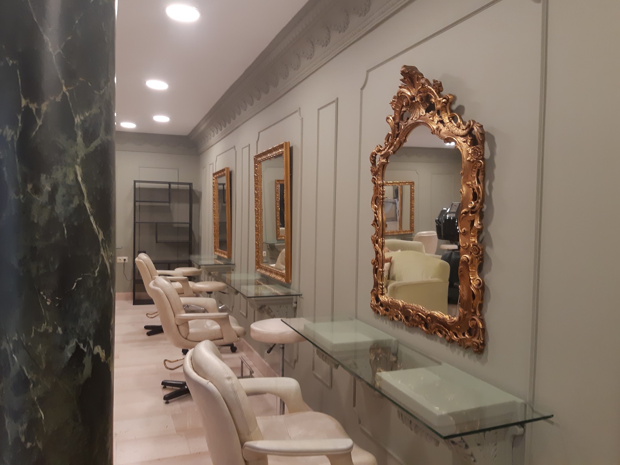 Interieur met sierlijsten langs het plafond, paneelwanden, gemarmerde zuil en vergulde spiegels